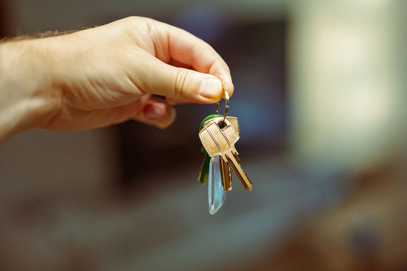 A hand holding up a small bunch of house keys
